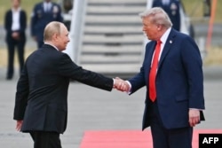 Президент США Дональд Трамп приветствует президента России Владимира Путина на взлетно-посадочной полосе после их прибытия в Анкоридж. Аляска, 15 августа 2025 года.Фото AFP